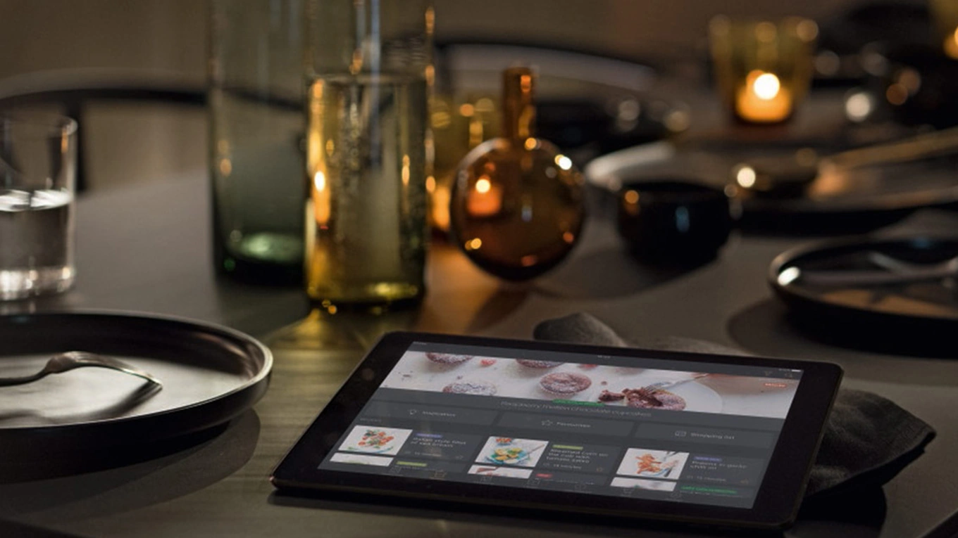tablet mit miele app auf dem display auf einer arbeitsplatte in der küche