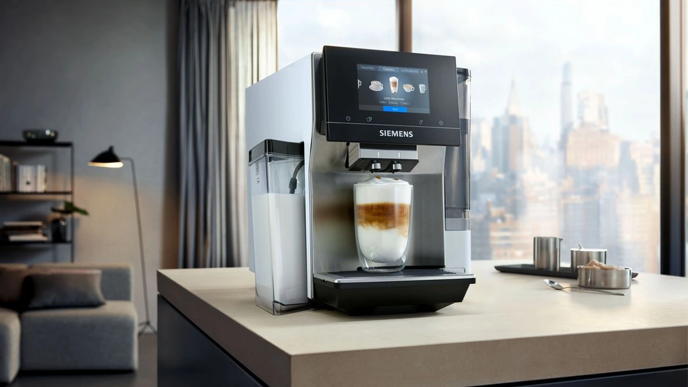 Siemens eq.700 Stand-Kaffeevollautomat siemens eq.700 stand kaffeevollautomat mit gefülltem latte macchiato glas in einer küche mit skyline ausblick